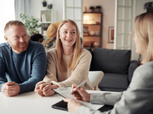 Image: A couple speaking with a woman in their home who is taking notes.